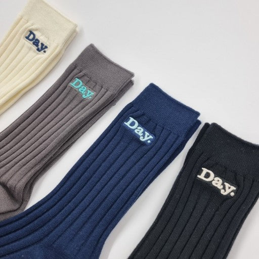 three pairs of socks with the words day on them