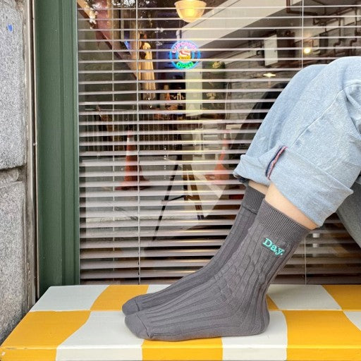 a person sitting on a window sill wearing socks